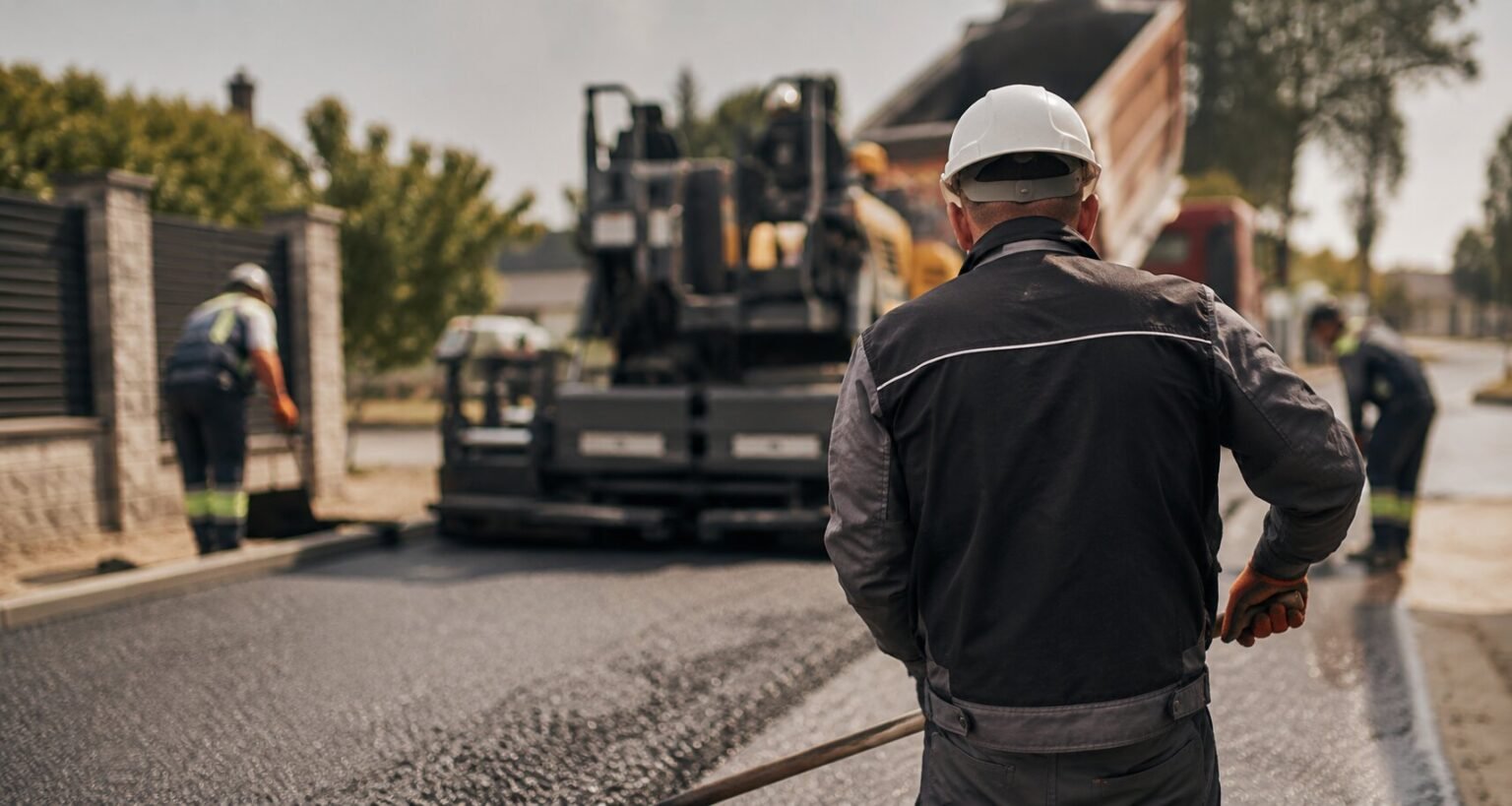 Bauarbeiter bei professionellen Asphaltarbeiten auf einer Baustelle in Deutschland